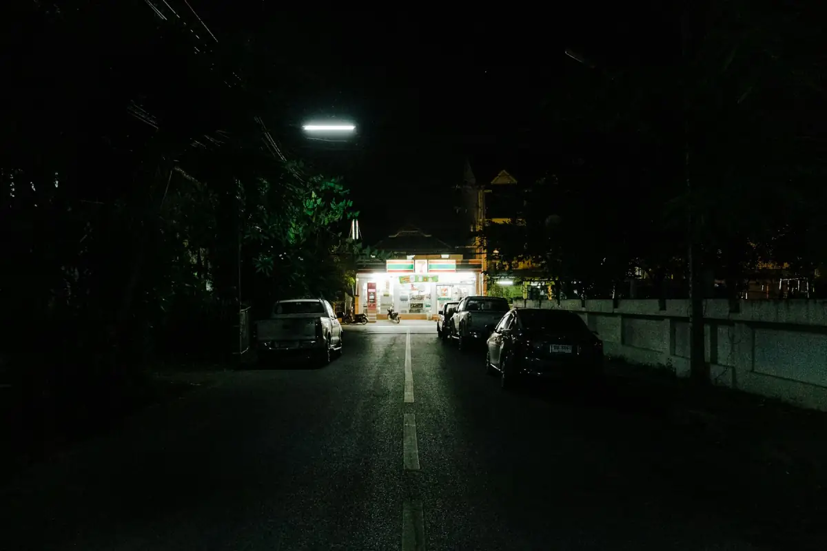 치앙마이 밤거리의 주차 차량과 불이 켜진 상점
