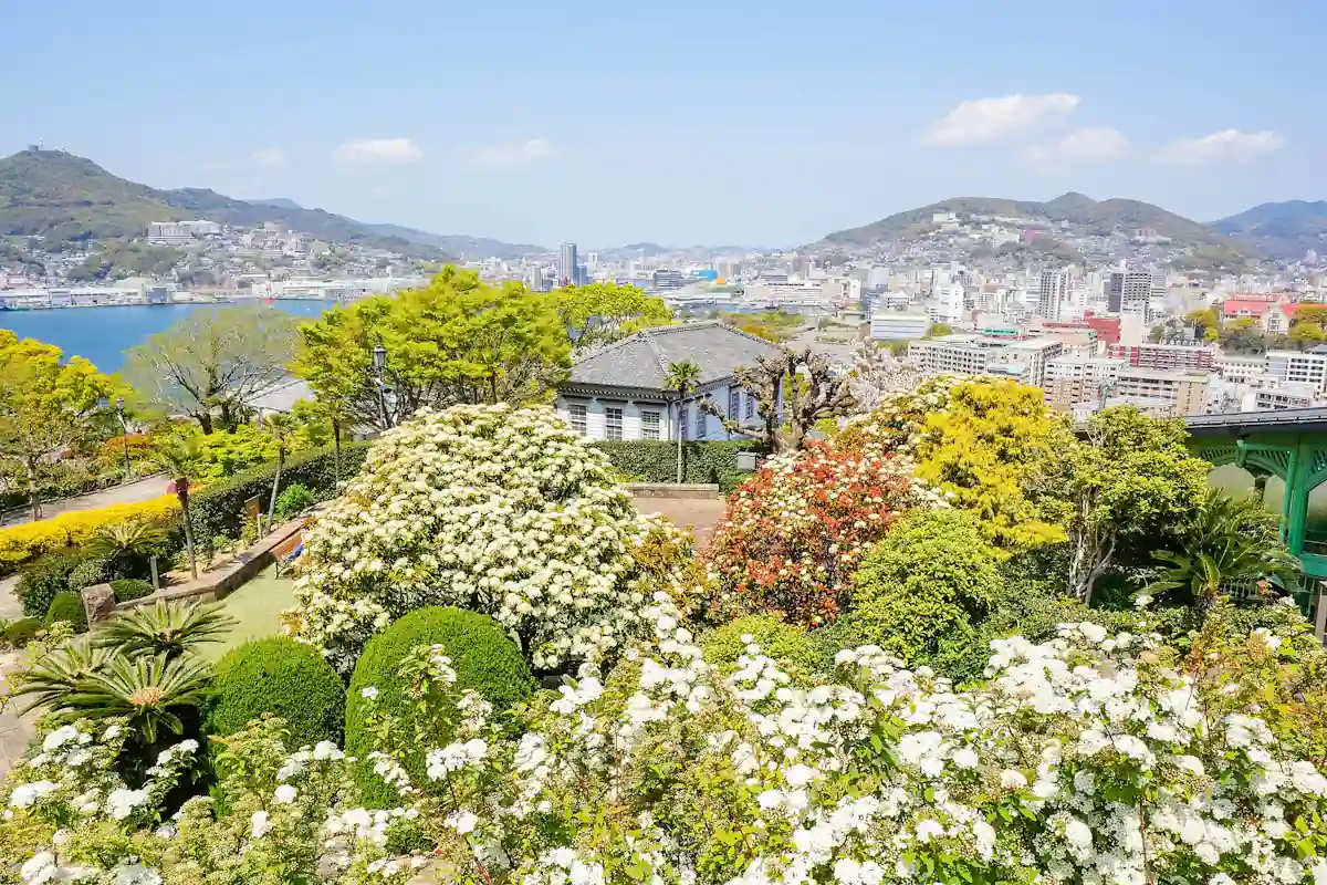 꽃이 핀 나가사키 글로버 정원 너머로 보이는 항구와 언덕의 주택