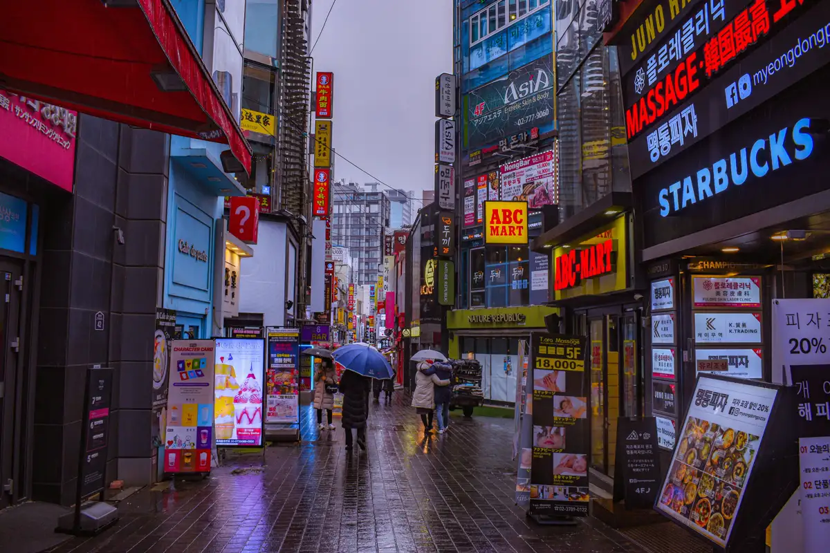 비 오는 명동 거리와 우산을 든 보행자