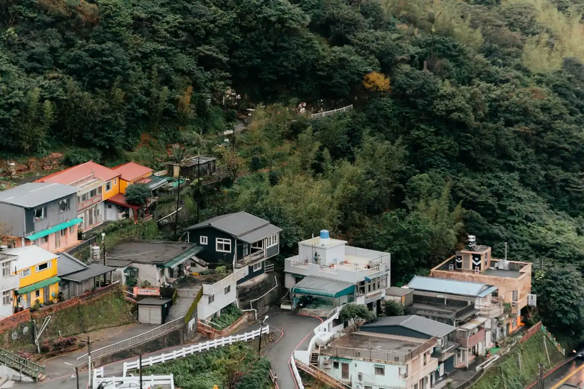 숲이 우거진 산비탈을 따라 모여 있는 지우펀의 주택과 좁은 도로